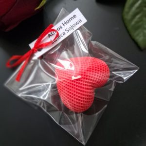 Recznie robiona swieca sojowa w ksztalcie czerwonego serca, zapakowana w przezroczystym woreczku z kokardka – uroczy, ekologiczny prezent na Walentynki - AtmosHome.pl