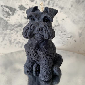 Ręcznie robiona naturalna świeca sojowa w kształcie czarnego psa sznaucera, ustawiona na lustrzanej podstawce - AtmosHome.pl