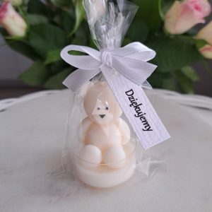 Ręcznie robiona świeczka sojowa w kształcie białego misia, zapakowana w przezroczysty woreczek z zawiązaną białą kokardką. Do woreczka przymocowana jest biała karteczka z napisem "Dziękujemy" - AtmosHome.pl