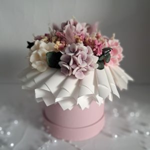 Różowy flower box z zapachowymi świecami sojowymi w kształcie hortensji, zielonym eukaliptusem, gipsówką i dmuszkami.