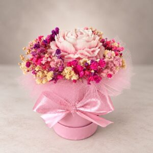Różowy flower box ze świecą sojową w kształcie piwonii i dekoracyjną kokardą